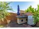 Outdoor kitchen with Traeger grill and patio umbrella at 9271 Keystone Ridge Ave, Las Vegas, NV 89148