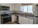 Modern kitchen with white cabinets, stainless steel appliances, and gray countertops at 1101 W Basin Ave, Pahrump, NV 89060