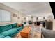 Open living room featuring teal sectional sofa, tan ottoman, and view into kitchen at 3264 Sutters Fort St, North Las Vegas, NV 89032