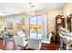 Bright dining room with glass table, white chairs, and access to backyard at 2795 Murray Hill Ln, Las Vegas, NV 89142