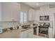 Modern kitchen with white cabinets, stainless steel appliances, and a farmhouse sink at 1450 Pink Dawn Dr, Henderson, NV 89014