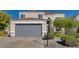 Two-story house with gray garage door and landscaping at 640 Badlands Ave, Henderson, NV 89012