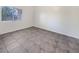 Simple bedroom with gray tiled floors and a window with blinds at 5650 E Sahara Ave # 2049, Las Vegas, NV 89142