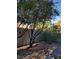 Backyard with trees, gravel, and a patio chair at 3418 Cinnamon Creek Ave, North Las Vegas, NV 89031