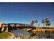 Wooden bridge over a calm lake with palm trees and desert landscape at 1254 Calcione Dr, Henderson, NV 89011