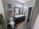 Modern bathroom with dark vanity, a large mirror, and updated fixtures at 690 Coastal Lagoon St, Henderson, NV 89002