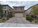 Two-story house with a beige facade and a brick driveway at 8105 Switchback Run St, Las Vegas, NV 89166