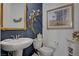 Elegant bathroom with pedestal sink, toilet and decorative wall art at 8286 Skye Gorge St, Las Vegas, NV 89166