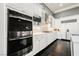 Modern kitchen with white cabinets, stainless steel appliances and dark hardwood floors at 11 Belfair Ct, Henderson, NV 89052