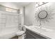 Bathroom features a gray vanity, quartz countertop and a large sunburst mirror at 101 S Royalite St, Sandy Valley, NV 89019