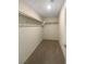 Spacious walk-in closet with double rods and neutral carpeting at 2621 Polar White Ave, North Las Vegas, NV 89086