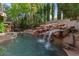 Stunning pool with a large, natural waterfall feature at 8309 Aqua Spray Ave, Las Vegas, NV 89128