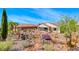 Landscaped backyard with desert plants, stone pathway, and unique sculptures at 2428 Hydrus Ave, Henderson, NV 89044