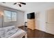 Bedroom with dark wood floors, featuring a dresser and a large window with blinds at 4129 Fabulous Finches Ave, North Las Vegas, NV 89084