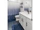 Clean bathroom with white vanity, tub shower, and blue patterned curtain at 10428 Rose Palisade St, Las Vegas, NV 89141