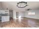 Sunlit living room with hardwood floors, chandelier and kitchen view at 6509 Dinning Ave, Las Vegas, NV 89107