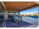 Covered patio with glass doors, table, chairs, and pool view at 9096 Becket Ranch Ct, Las Vegas, NV 89113