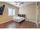 Bright bedroom with wood floors, a ceiling fan, and a built-in shelving unit at 10668 Porta Romana Ct, Las Vegas, NV 89141