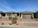 Single-story home with a brown front door and attached garage,landscaped yard at 76 Ella Ashman Ave, Henderson, NV 89011