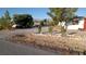 Gravel driveway and yard with mature trees at 5200 Bonnie St, Pahrump, NV 89048