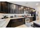 Modern kitchen with dark wood cabinets, granite countertops and stainless steel appliances at 7626 Peaceful Trellis Dr, Las Vegas, NV 89179