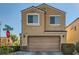 Two story home with tan exterior and a two car garage at 5662 Point Loma Ct, Las Vegas, NV 89122