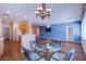 Dining area with glass table, blue accent wall, and kitchen access at 2435 Moonlight Valley Ave, Henderson, NV 89044