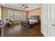 Spacious bedroom with a large bed, massage chair, and dark wood floors at 429 Proud Eagle Ln, Las Vegas, NV 89144