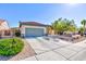 Single-story home with a gray garage door, landscaping, and a driveway at 2341 Rosendale Village Ave, Henderson, NV 89052