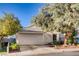 One-story home with a white garage door and mature trees in the front yard at 8665 Freeport Ln, Las Vegas, NV 89117