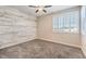 Bedroom with wood-look accent wall and ceiling fan at 4787 E Beacon Ridge Dr, Pahrump, NV 89061