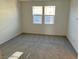 Sunny bedroom with grey carpet and two windows at 742 Monroe Hill Pl, Henderson, NV 89011