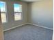 Bright bedroom with neutral carpeting and large windows at 7215 Stockton Dunes St, North Las Vegas, NV 89084