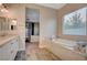 Bathroom features a large soaking tub, double vanity, and view of bedroom at 7083 Arabian Ridge St, Las Vegas, NV 89131