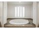 Relax in this bathroom featuring a large oval tub and granite at 207 Crooked Putter Dr, Las Vegas, NV 89148