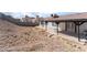 Large backyard with a covered patio and rocky landscape at 2222 Little River Ct, Las Vegas, NV 89156