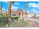 Two story house with tan exterior, two car garage, and palm trees at 2098 Merano Ct, Las Vegas, NV 89123