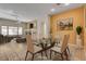 Virtually staged dining room with glass table and chairs, adjacent to living room at 85 Alerion St, Las Vegas, NV 89138