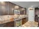 Well-equipped kitchen with dark cabinetry and granite countertops at 677 Coastal Lagoon St, Henderson, NV 89002