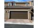 Two-car garage with a brown door and brick driveway at 2818 Turnstone Ridge St, Henderson, NV 89044