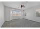 Bright bedroom with grey carpet, ceiling fan and large windows at 9524 Grand Grove Ct, Las Vegas, NV 89149