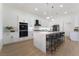 Modern kitchen with white cabinets, marble island, and stainless steel appliances at 2528 Sunup Dr, Las Vegas, NV 89134