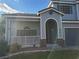 Two-story house with gray siding, arched entryway, and a small porch at 7621 Natures Song St, Las Vegas, NV 89131