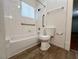 Bathroom featuring white tile, bathtub, toilet, and grab bars at 615 Harrison Ave, Las Vegas, NV 89106