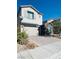 Two-story house with gray exterior, stone accents, and a two-car garage at 6854 Chargehand Ave, Las Vegas, NV 89156