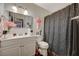 Clean bathroom with white vanity and dark shower curtain at 7019 Grassy Knoll St, Las Vegas, NV 89147