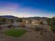 Aerial view of a house with a yard and mountain views at dusk at 2500 S Zephyr Ave, Pahrump, NV 89048