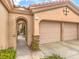 Two-car garage with arched entry, decorative metal gate and nicely manicured landscaping at 4 Kennesaw Rd, Henderson, NV 89052