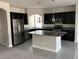 Modern kitchen with island and stainless steel appliances at 7053 Parrot Bay Way, Las Vegas, NV 89118