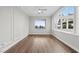 Bright living room with large arched windows, wood-look flooring, and a ceiling fan at 2840 Soaring Peak Ave, Henderson, NV 89052